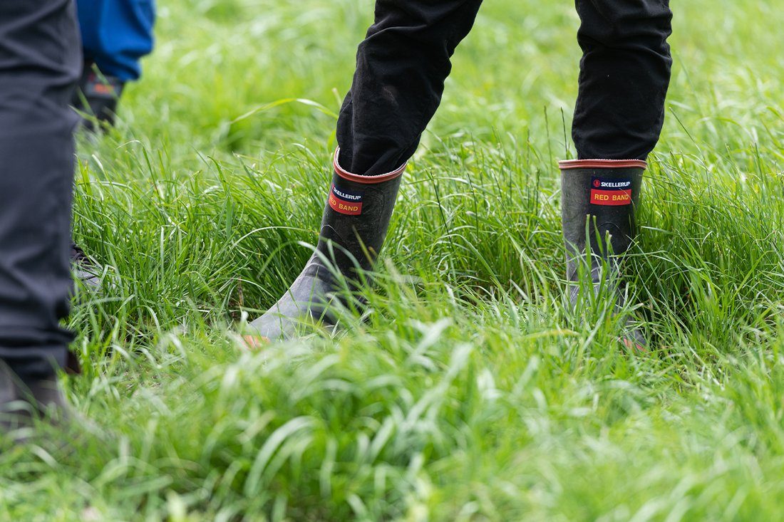 Farmer wearing gumboots standing on grass