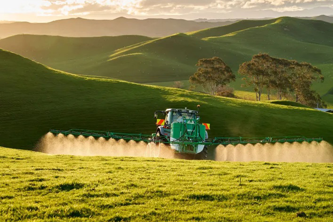 Tractor spraying weeds in paddock