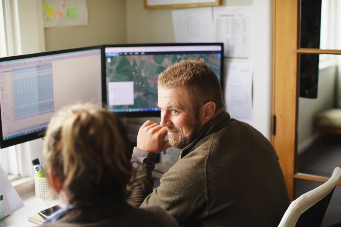 Farmers gathered around a computer